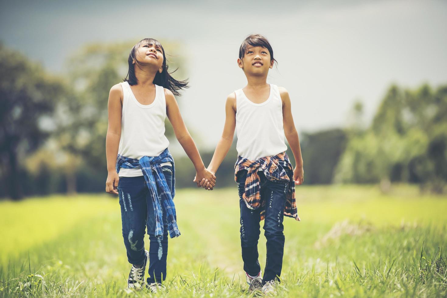 deux petites filles se tenant la main dans le parc photo