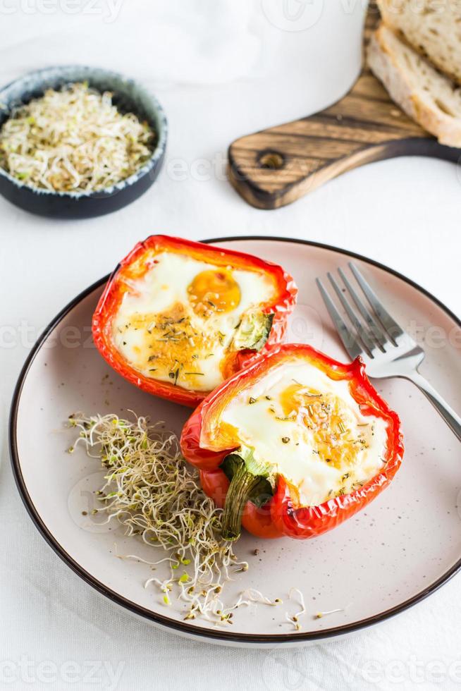 prêt à manger cloche poivre moitiés cuit avec Oeuf et microgreens sur une assiette sur le tableau. en bonne santé biologique régime. verticale vue photo