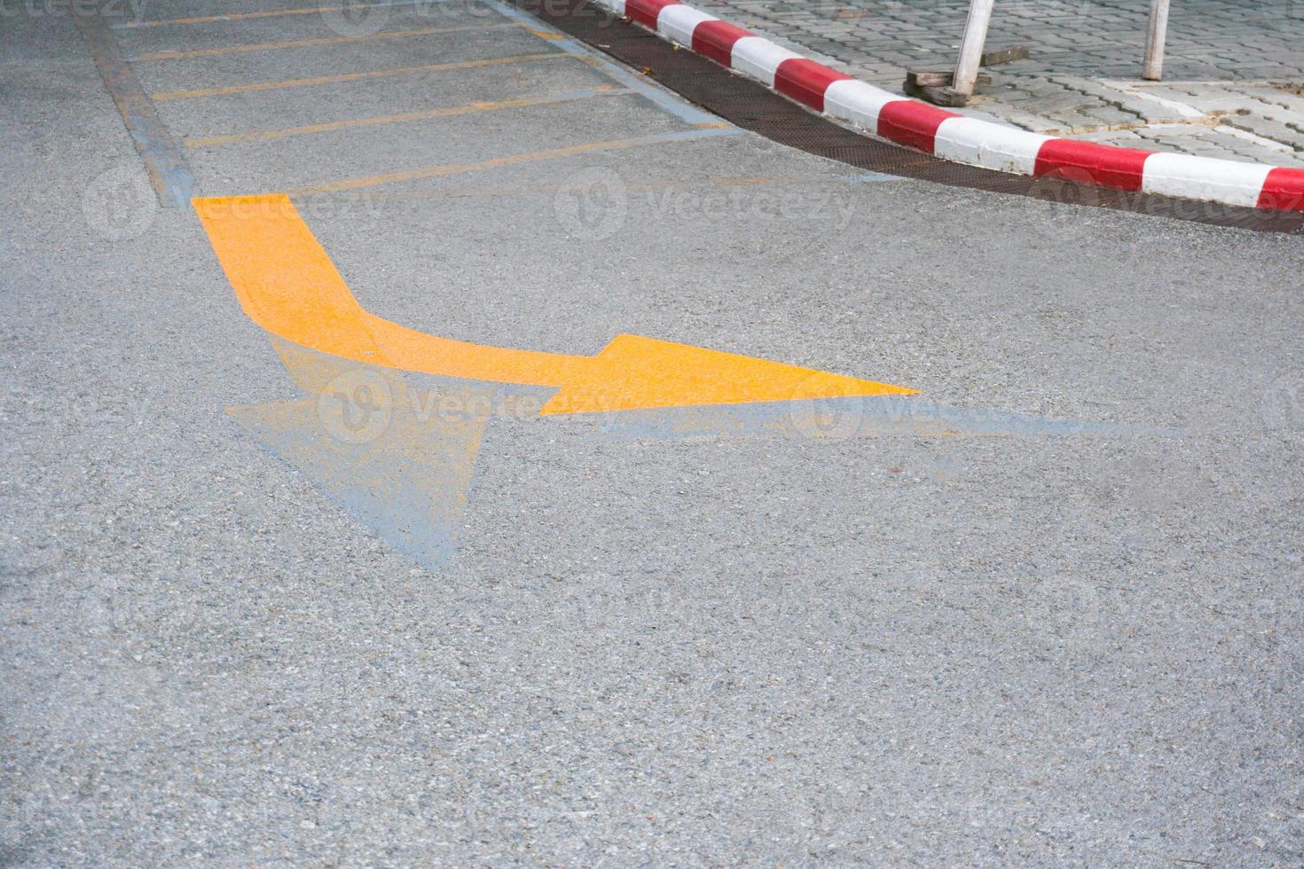 circulation panneaux ,jaune La Flèche tournant droite route signe sur le route sol photo