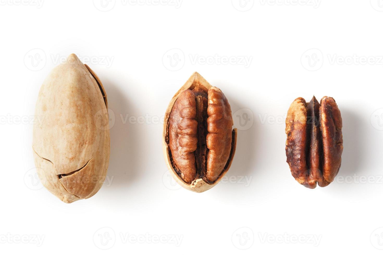ensemble de trois noix de pécan au centre dans une coquille, pelées et sans coquille isolées sur fond blanc d'affilée. photo