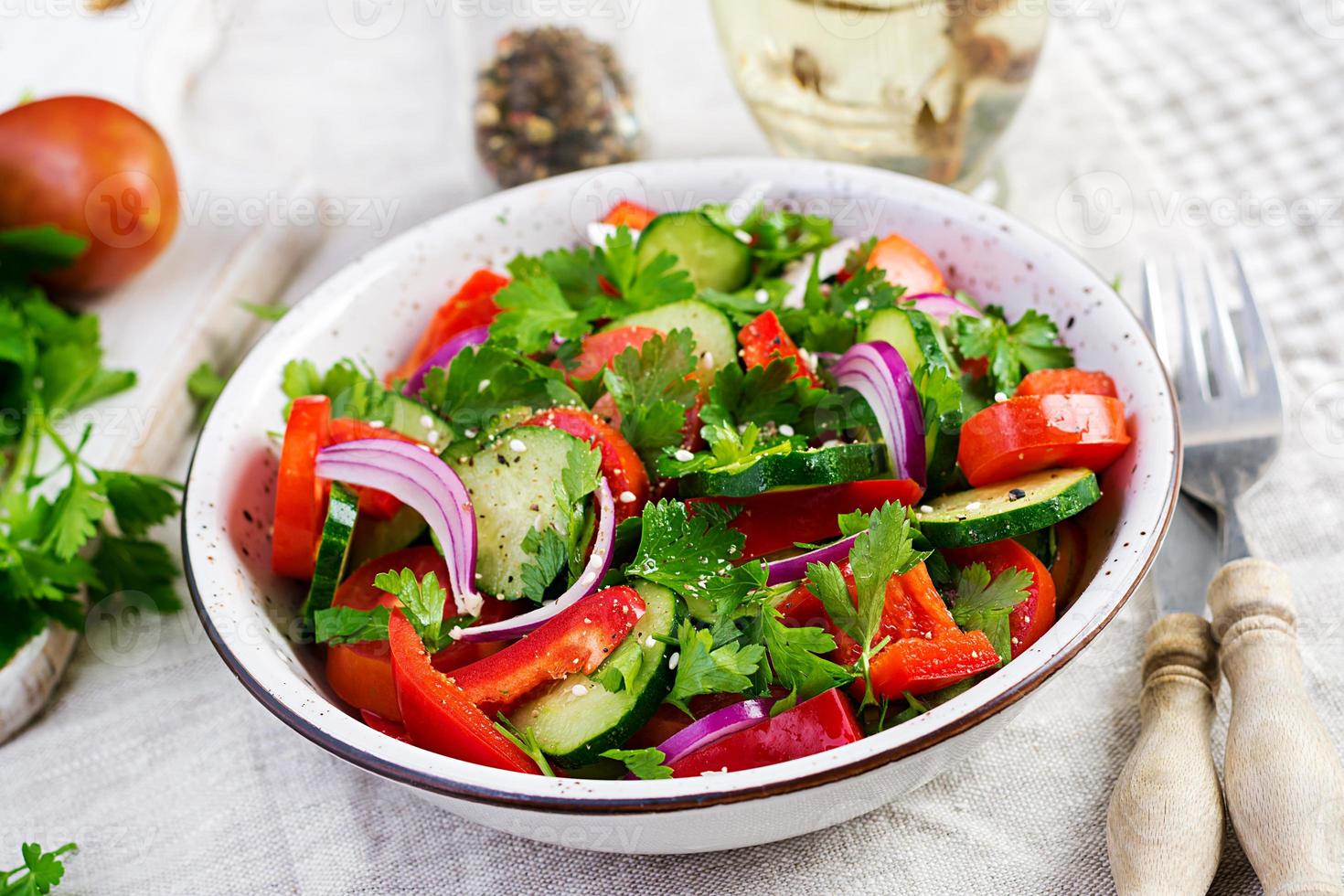 tomate et concombre salade avec rouge oignon, paprika, noir poivre et persil. végétalien aliments. régime menu. photo