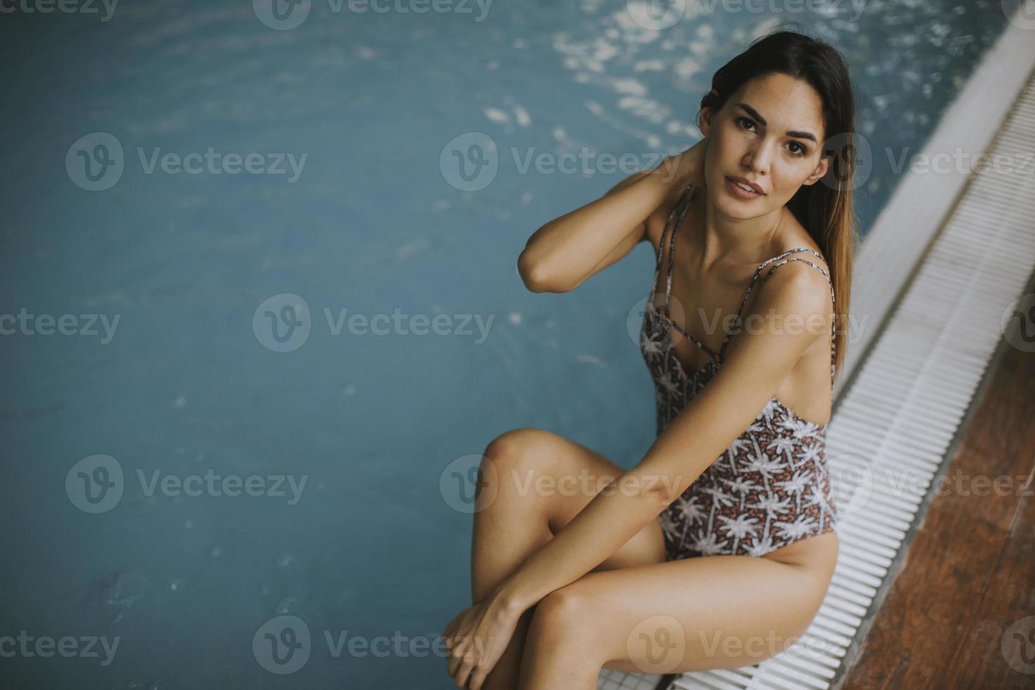 belle jeune femme assise au bord de la piscine photo