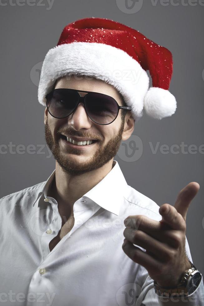 Beau jeune homme barbu avec un portrait de chapeau de Noël photo