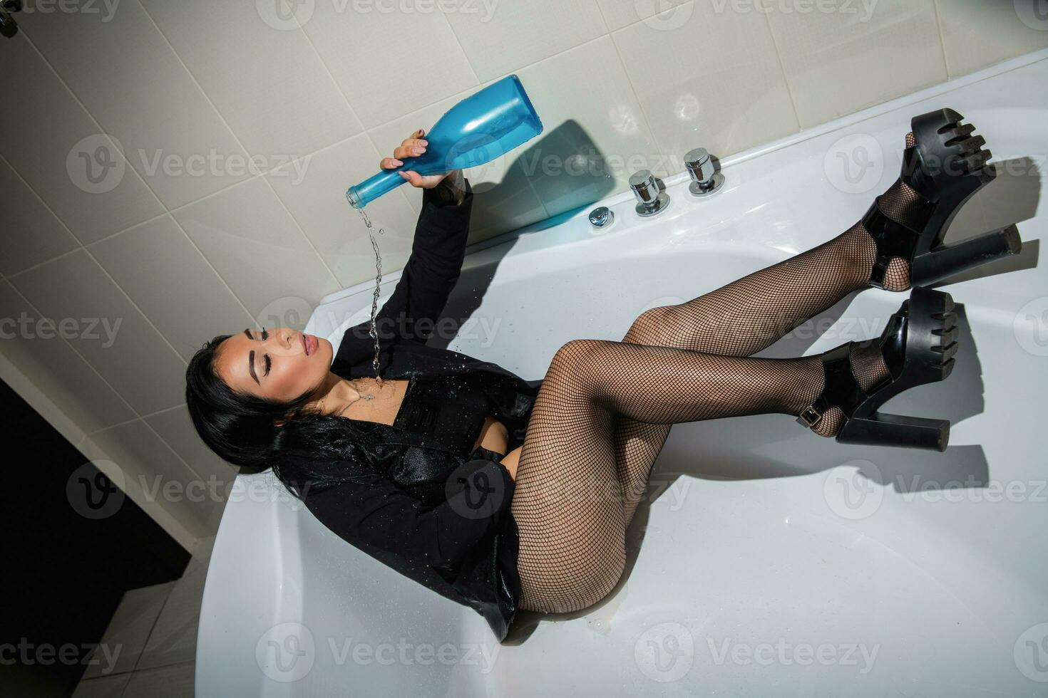 agréable brunette posant dans une baignoire photo