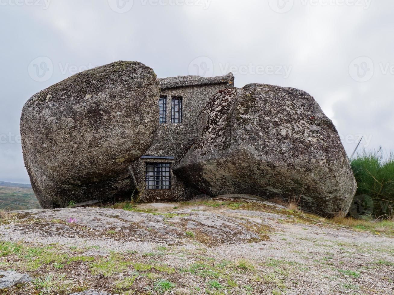 rocher maison ou casa faire pendu, une maison construit entre énorme rochers sur Haut de une Montagne dans faé, le Portugal. d'habitude pris en considération un de le le plus étrange Maisons dans le monde. photo