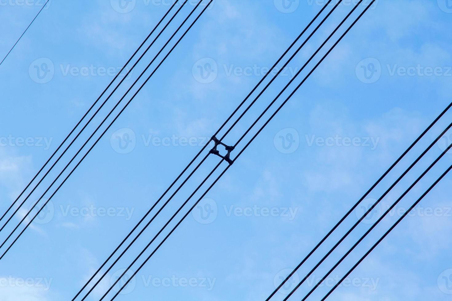 haute tension et isolé câbles suspendu dans le bleu ciel sont câbles cette porter électricité et électricité pour gens et beaucoup industriel les plantes et entreprises cette avoir besoin électricité. photo