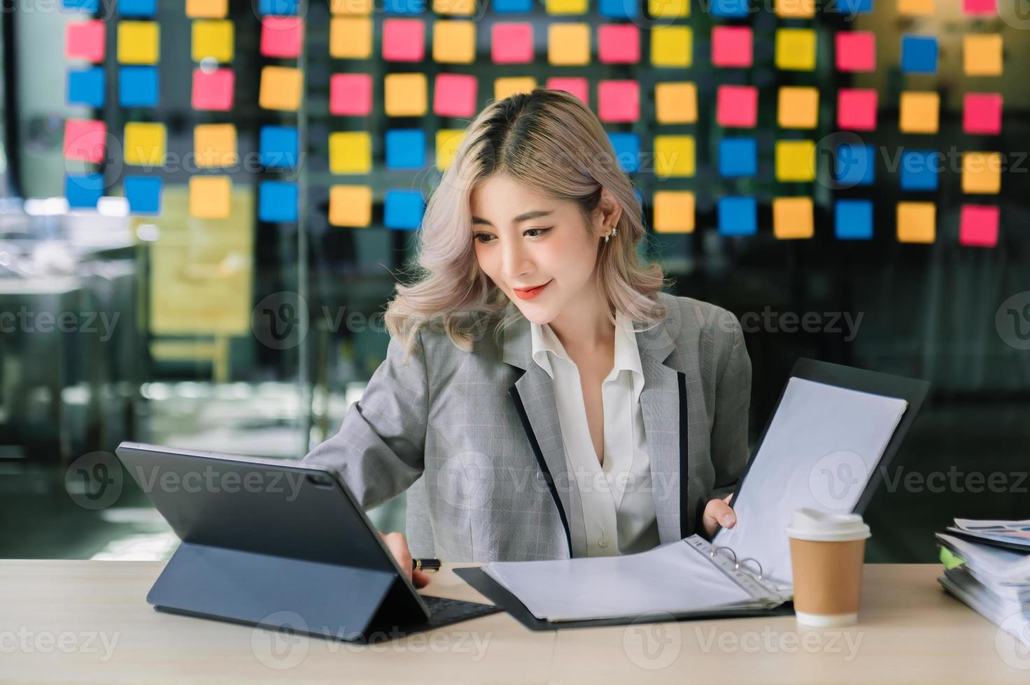 une femme indépendante travaille son travail sur une tablette d'ordinateur et un ordinateur portable faisant un rapport d'analyse comptable des données d'investissement immobilier, financière au bureau photo