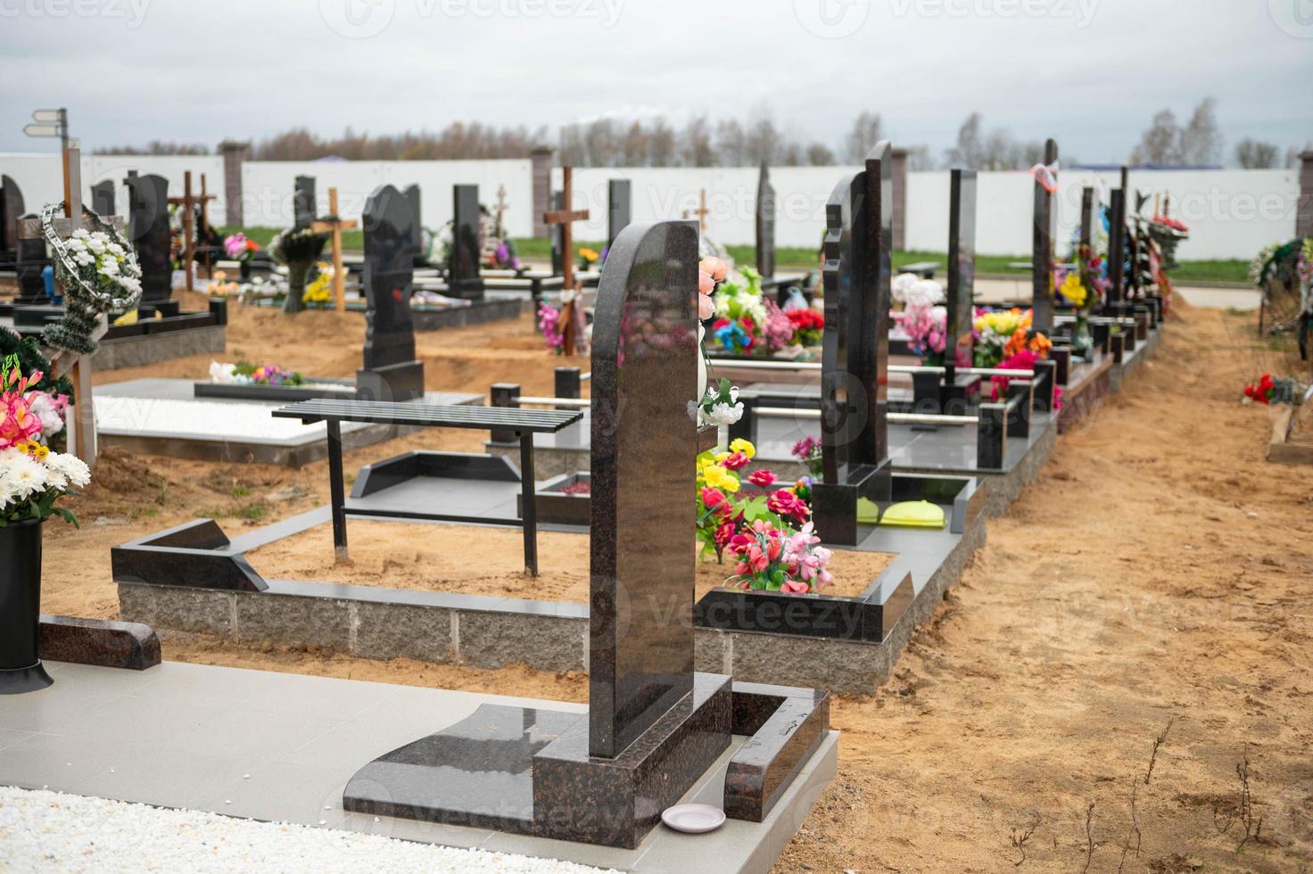 la tombe des croix avec couronnes de fleurs dans le cimetière sur le le sable photo