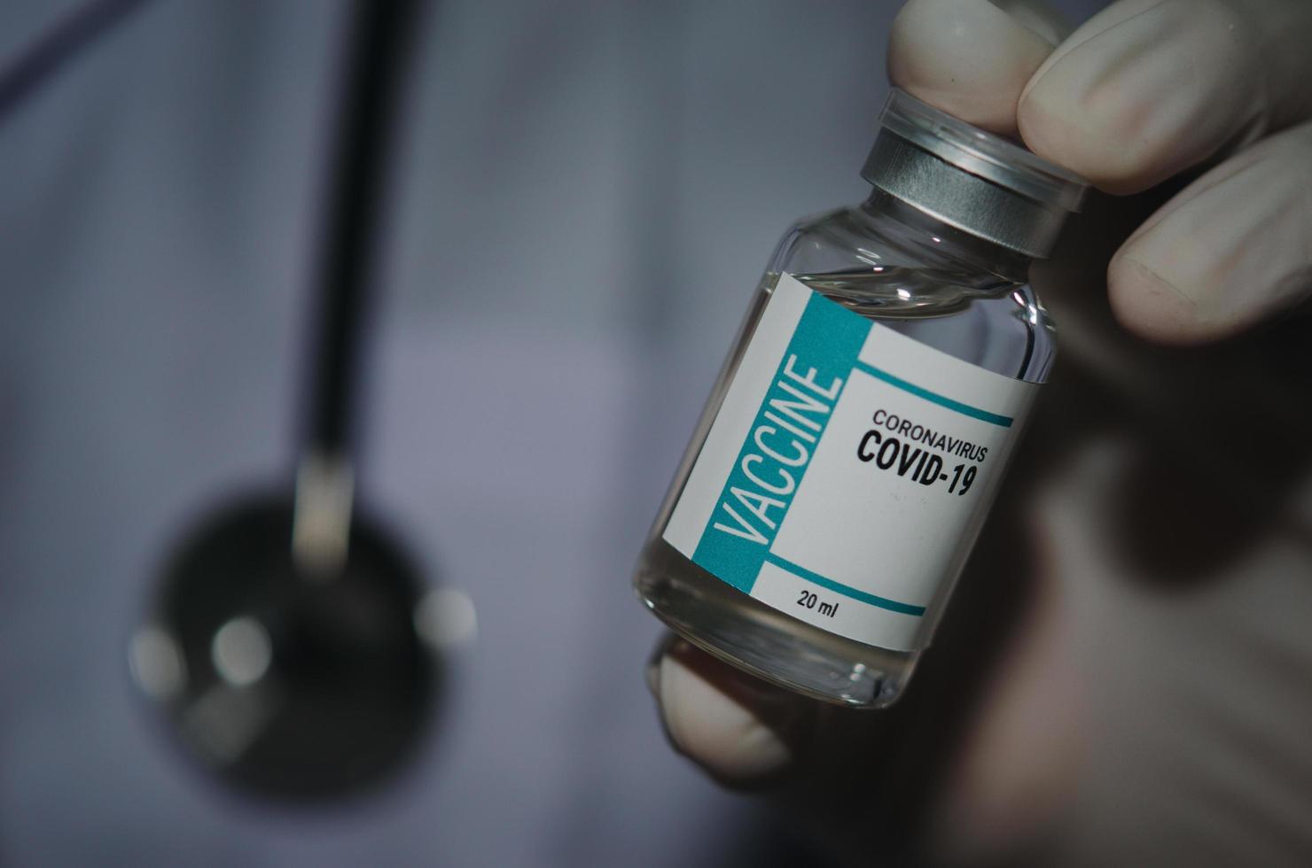 un médecin de sexe masculin tenant une bouteille de covid-19 ou de vaccin contre le coronavirus photo
