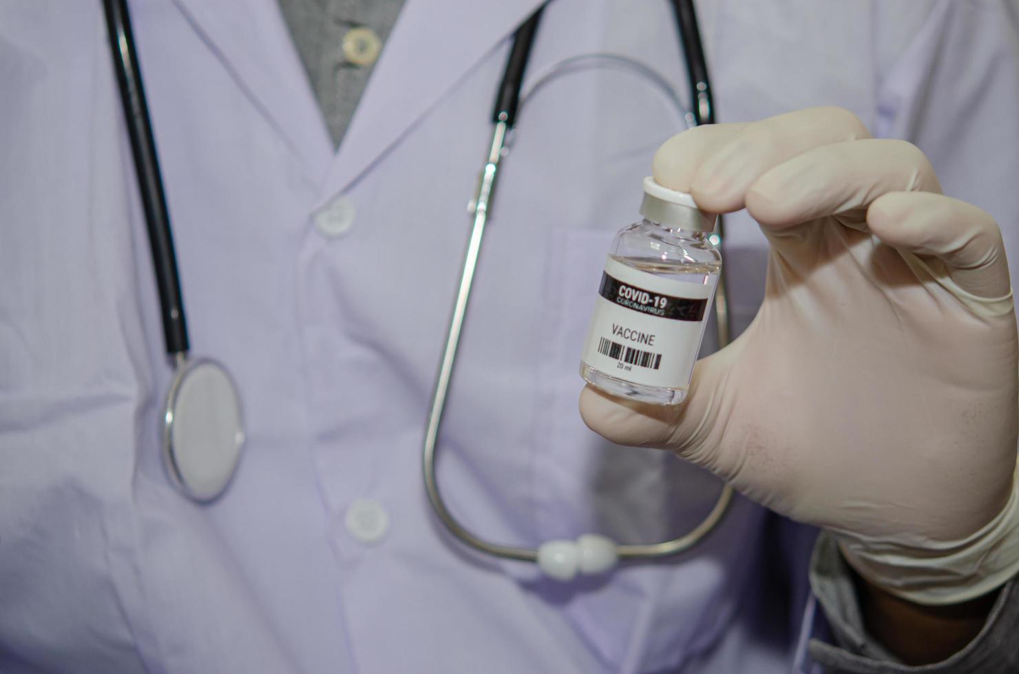 un médecin de sexe masculin tenant une bouteille de covid-19 ou de vaccin contre le coronavirus photo