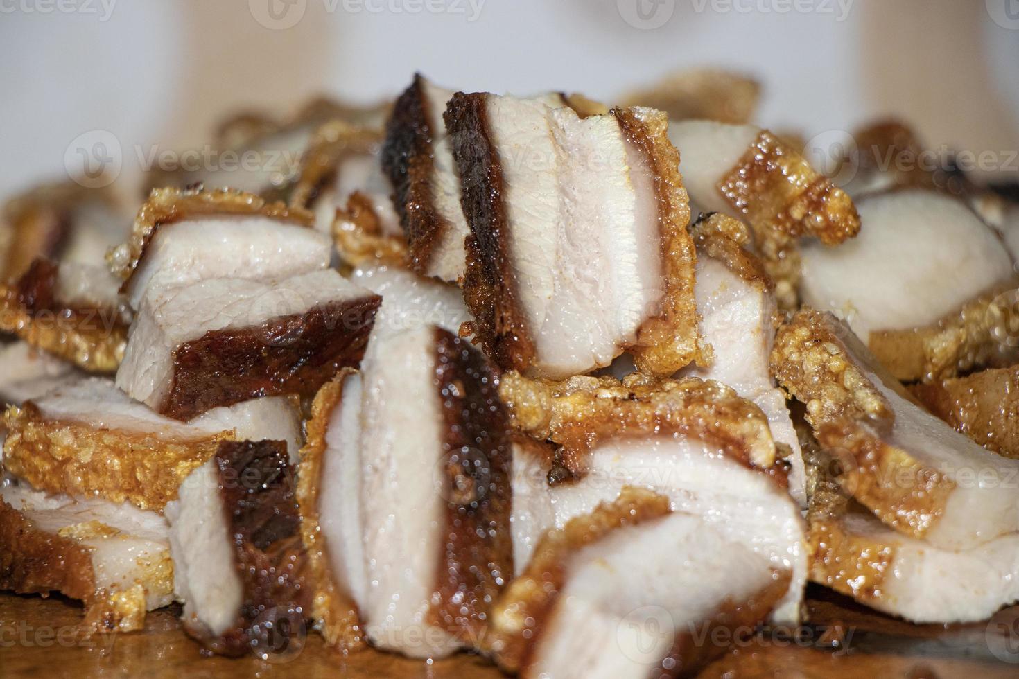 Close-up de tranches de poitrine de porc frit sur table en bois photo