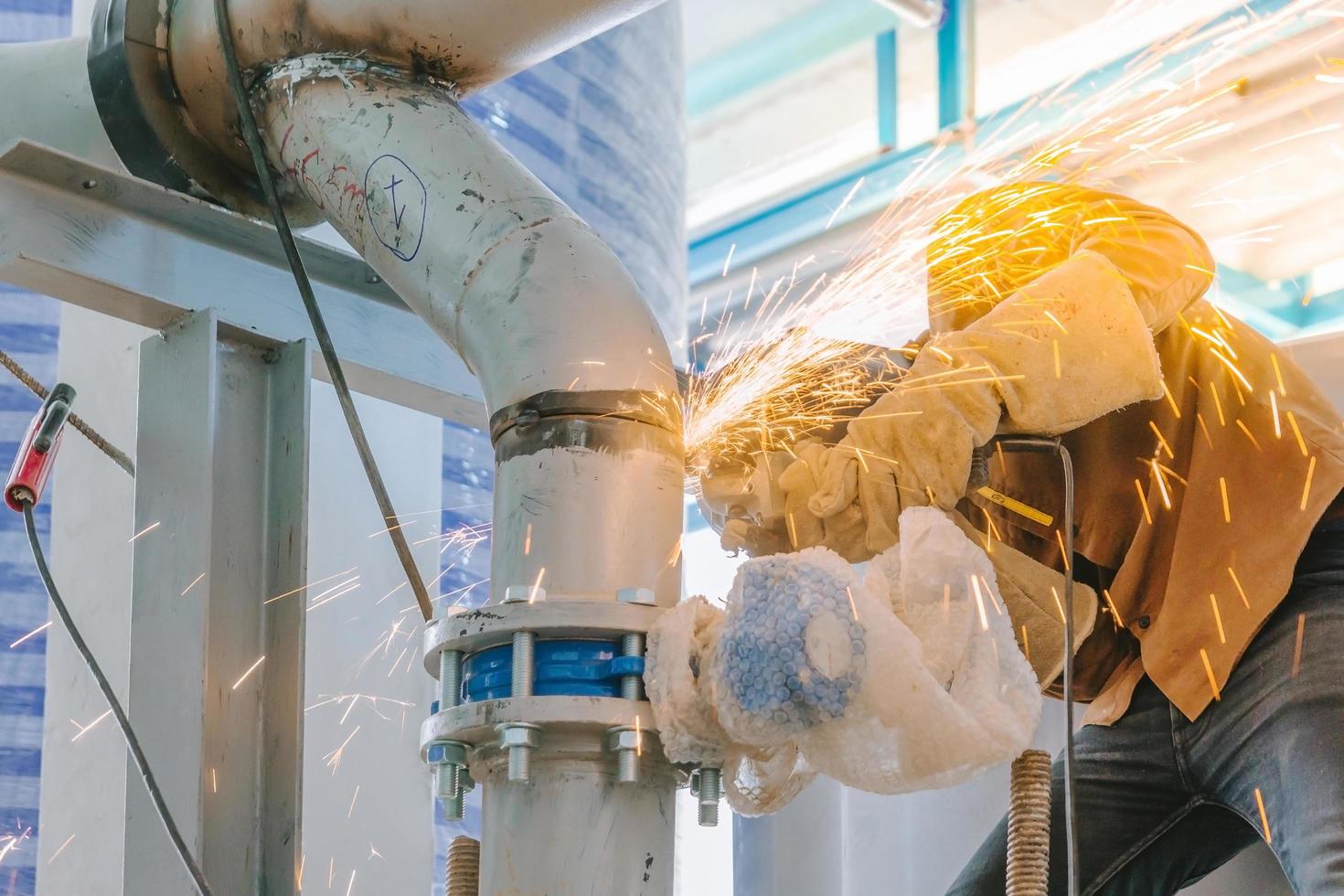 tuyau d'acier de meulage de travailleur de l'industrie lourde photo