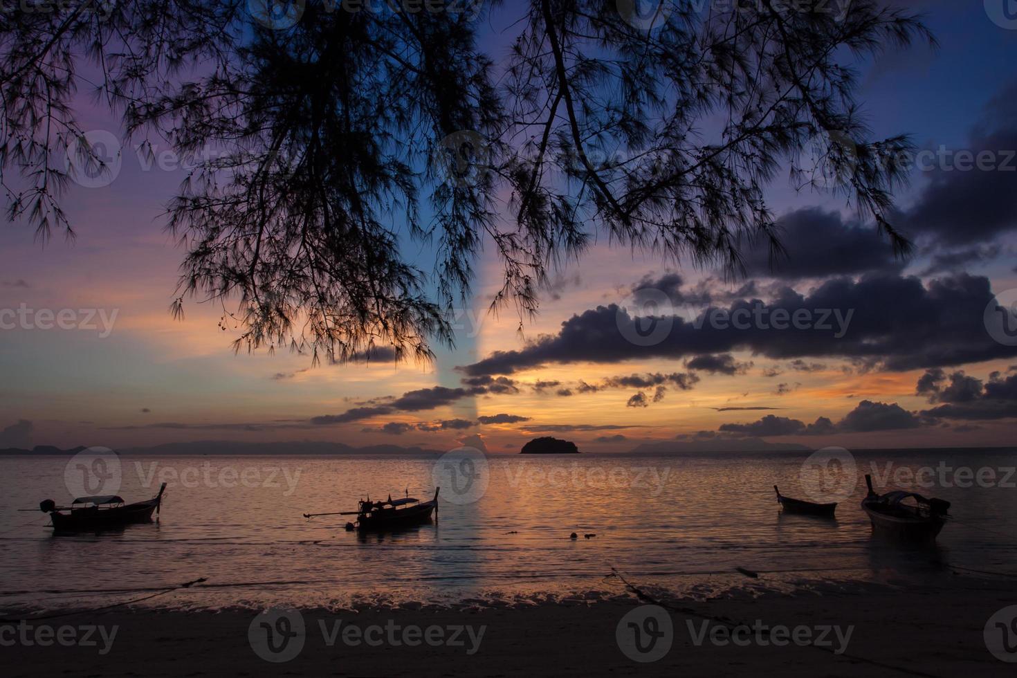 silhouette de bateaux sur l'océan au coucher du soleil photo