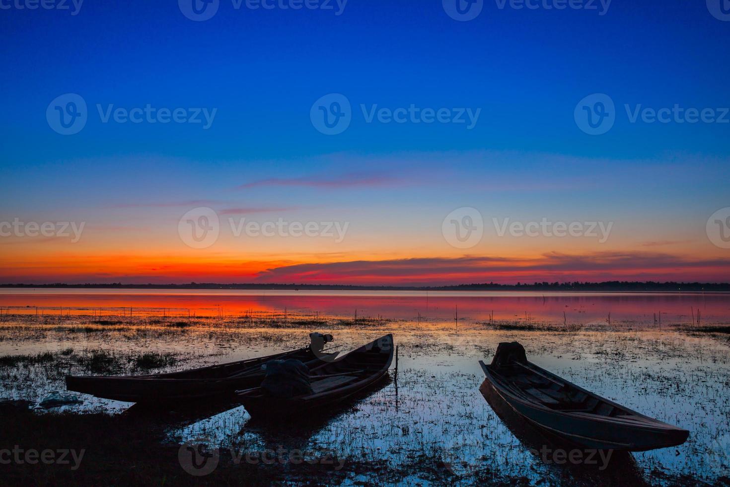 coucher de soleil coloré avec des chaloupes dans l'eau photo