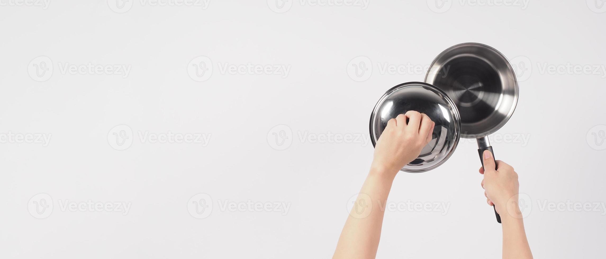 main d'homme de nettoyage de pot sur fond blanc nettoyant le pot antiadhésif avec une éponge à vaisselle pratique de couleur jaune sur le côté doux et verte sur le côté dur pour l'hygiène après la cuisson. marmite électrique photo