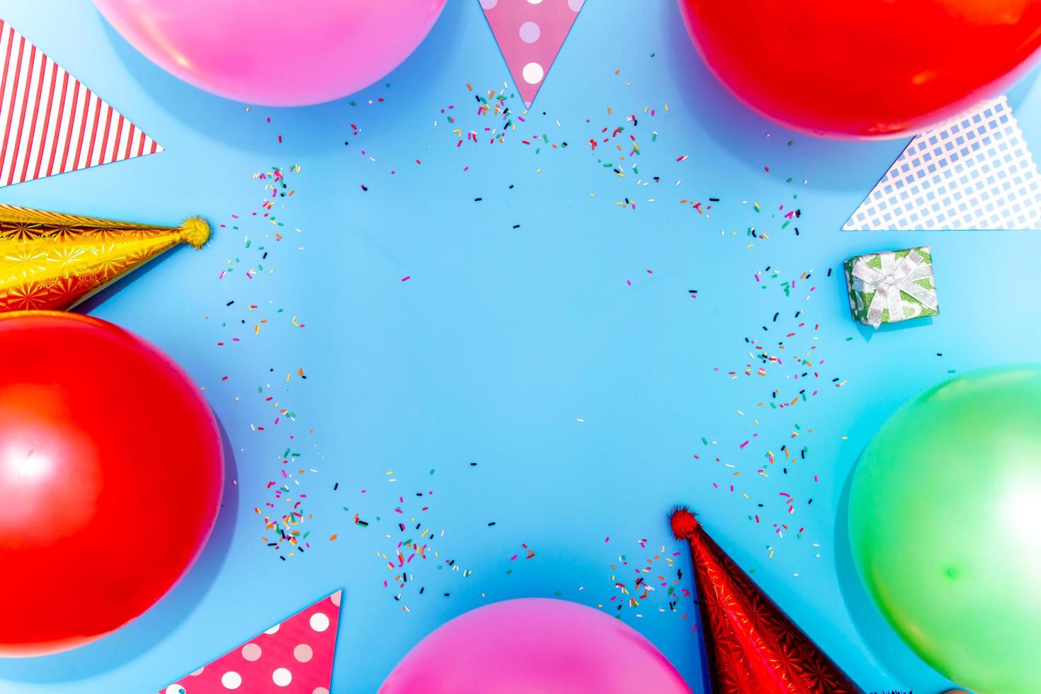 coloré des ballons et confettis sur bleu table Haut voir. de fête ou fête Contexte. photo