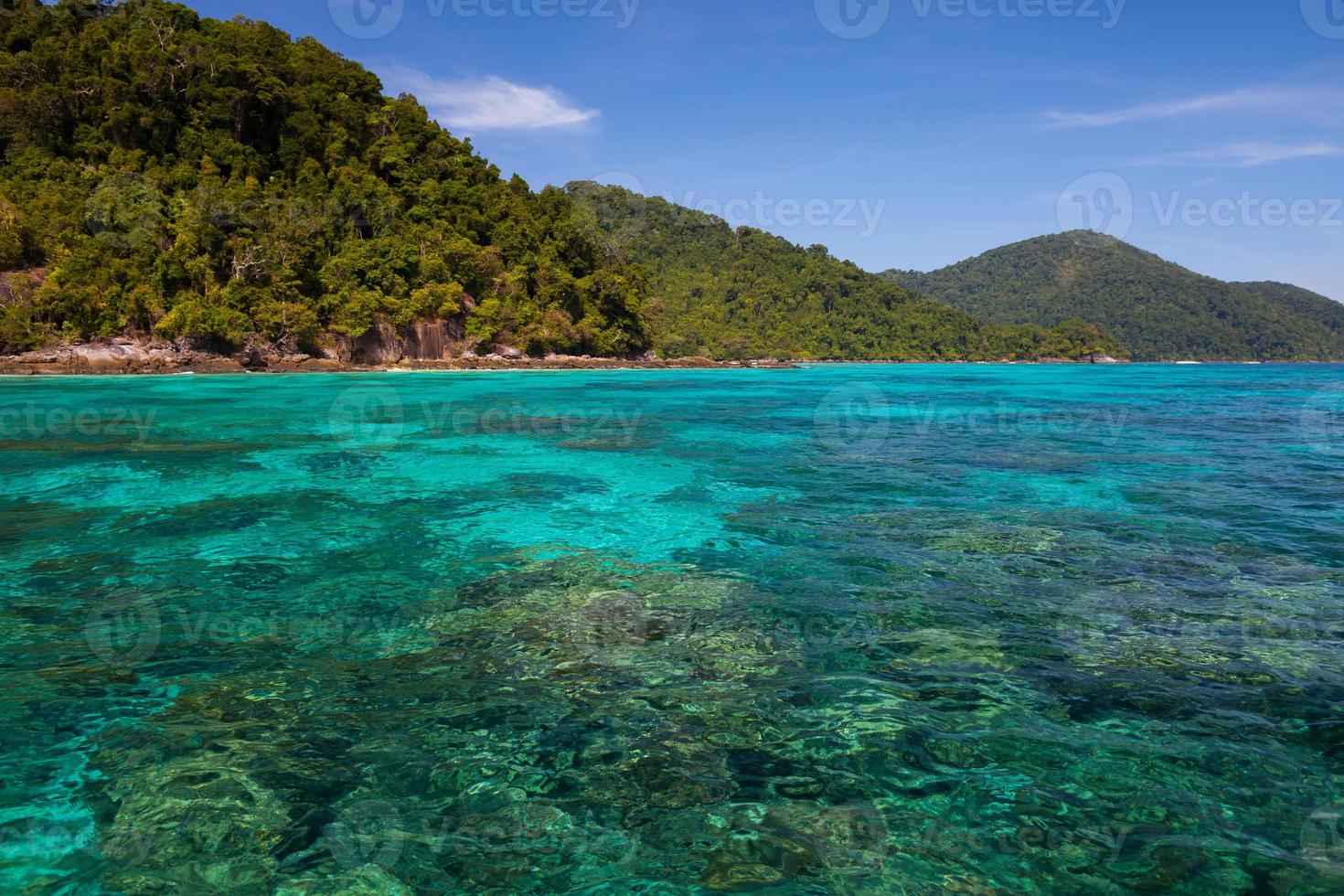 mer bleue avec des montagnes vertes photo