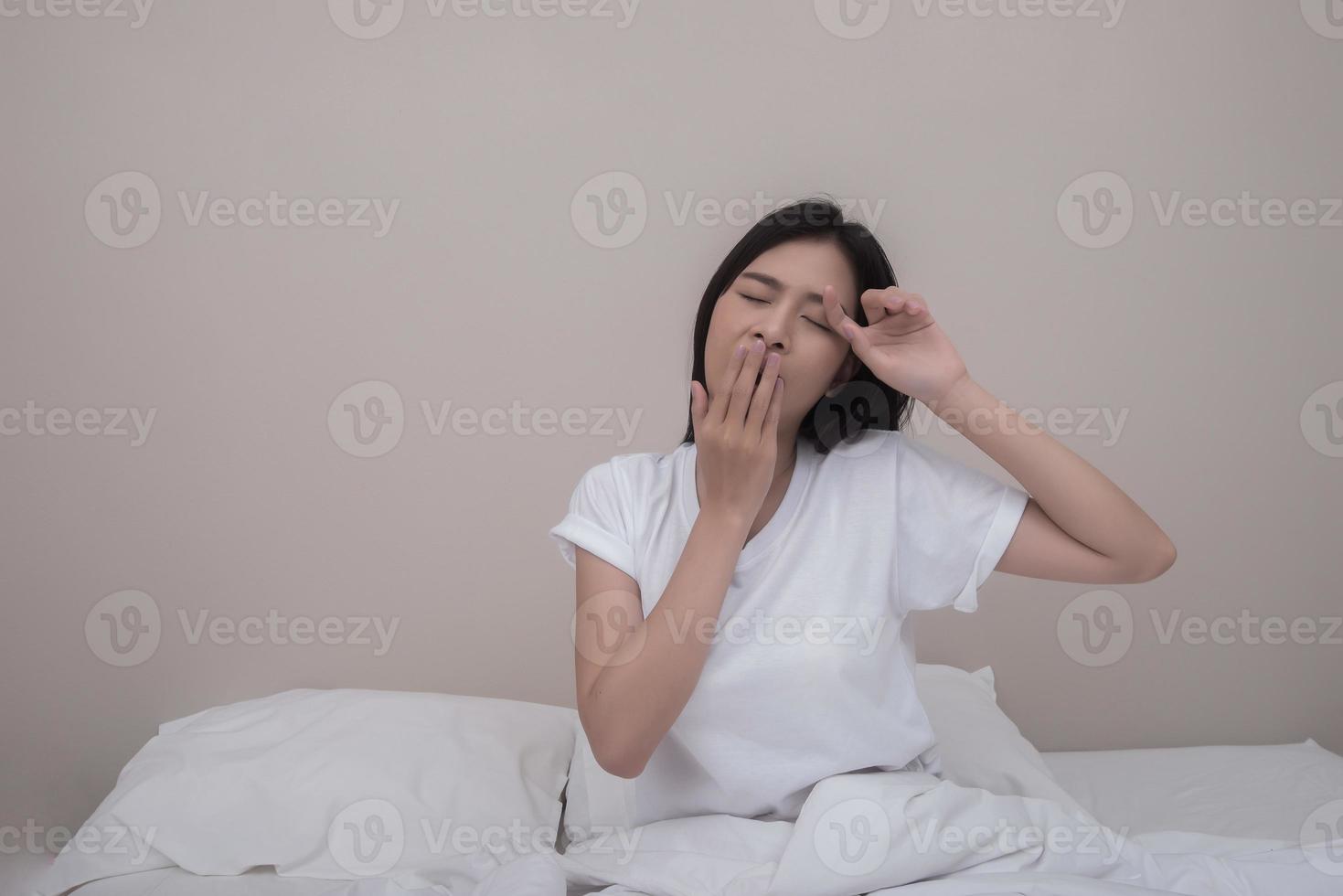 femme heureuse qui s'étend dans son lit à la maison le matin photo