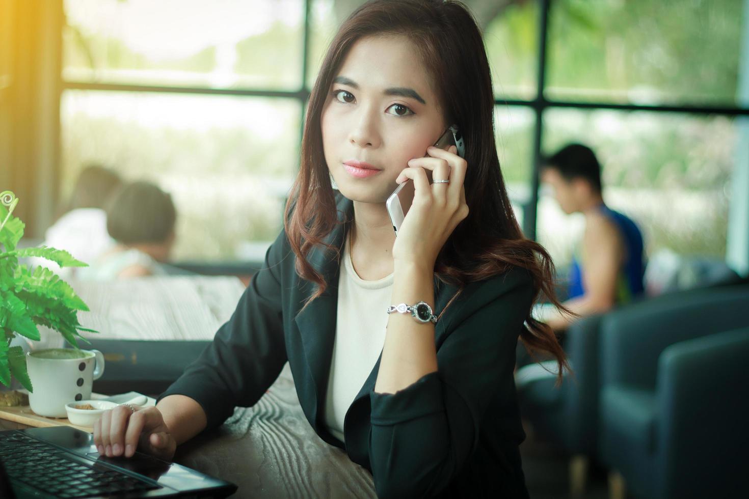 femme asiatique est au téléphone dans un café photo