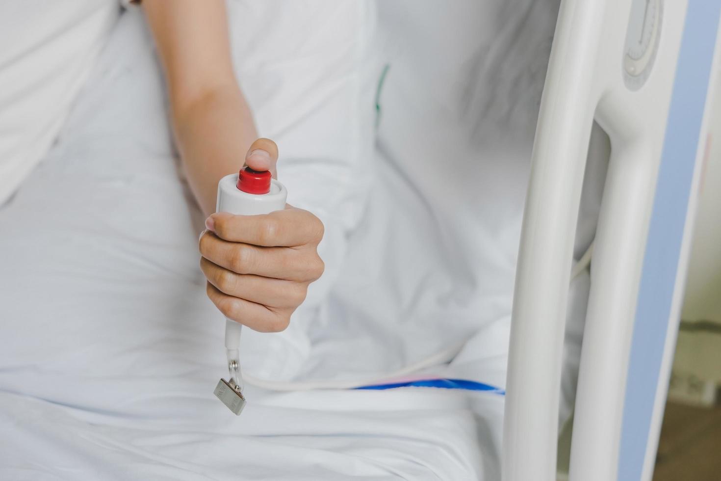 Gros plan de la main du patient en appuyant sur le bouton d'urgence photo