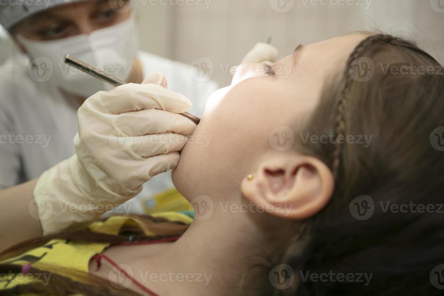 le enfant est étant traité pour les dents dans le dentaire bureau.enfant dans le dentiste Bureau photo