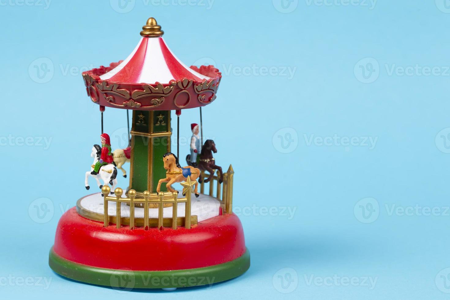 carrousel de jouets vintage sur fond bleu. carillon rouge avec carrousel, carrousel rétro photo
