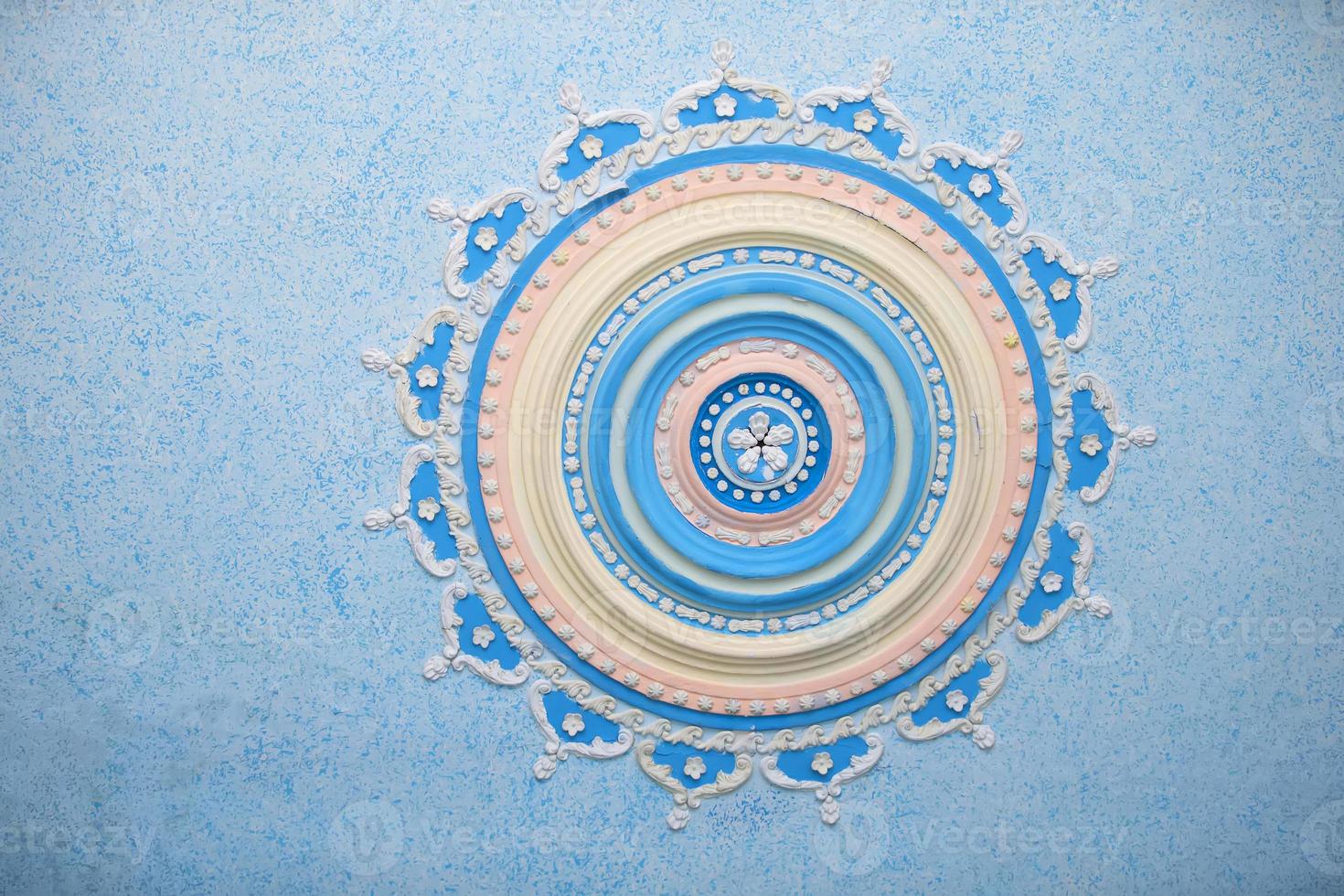 rond magnifique stuc modèle sur le plafond. le soulagement plâtre, le soulagement modèle bleu Contexte. partie de un vieux plafond décoré avec une argile modèle. photo