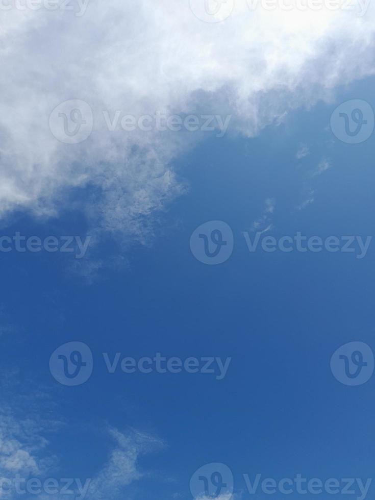 beaux nuages blancs sur fond de ciel bleu profond. de grands nuages doux et moelleux couvrent tout le ciel bleu. photo