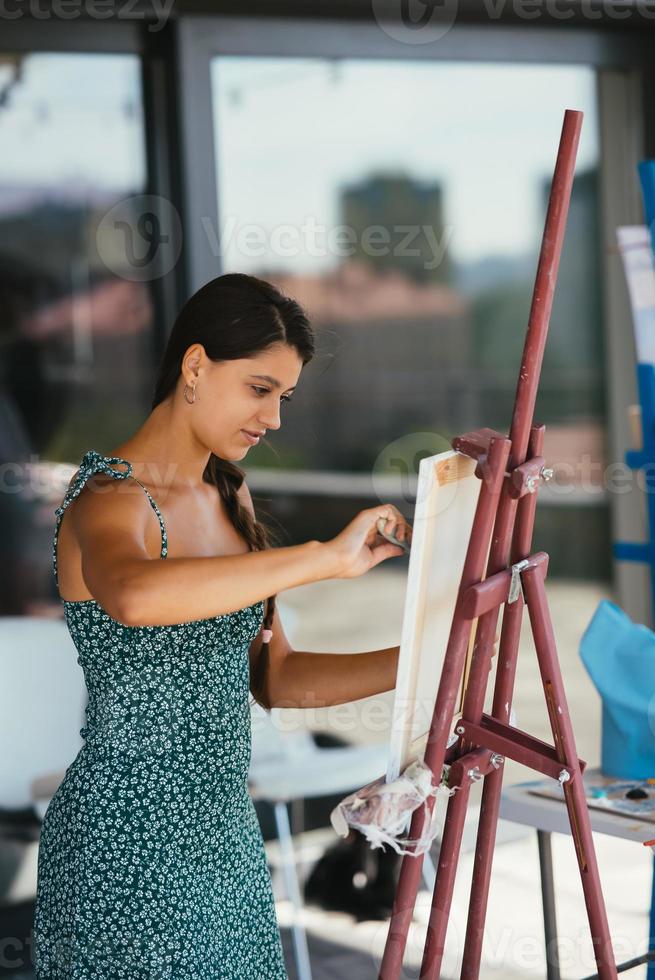 jeune femme artiste peint avec une spatule sur la toile photo