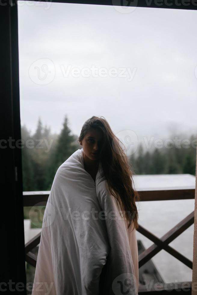 jeune femme enveloppée dans une couverture sur le balcon photo