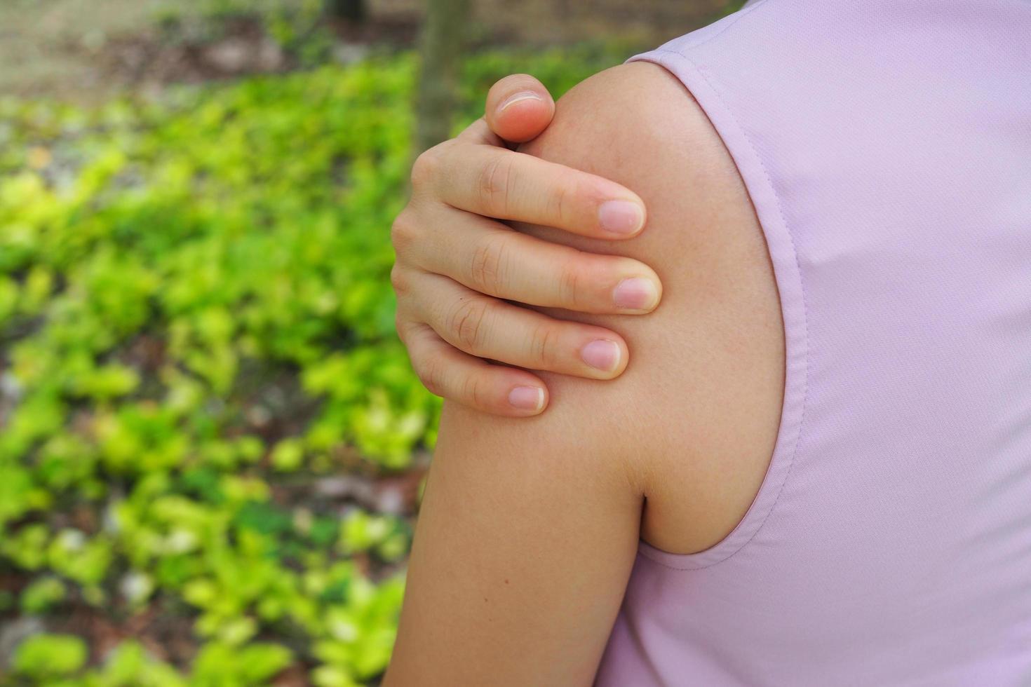 le fille a épaule muscles douleur. photo