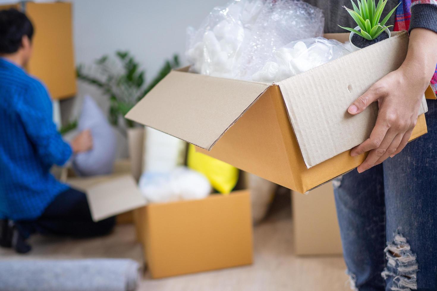 le épouse levé le espace de rangement boîte. des couples Aidez-moi chaque autre à garder leur affaires et bouge toi à une Nouveau maison. photo