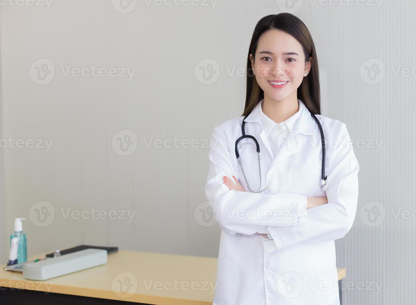 belle jeune femme asiatique médecin debout avec les bras croisés photo