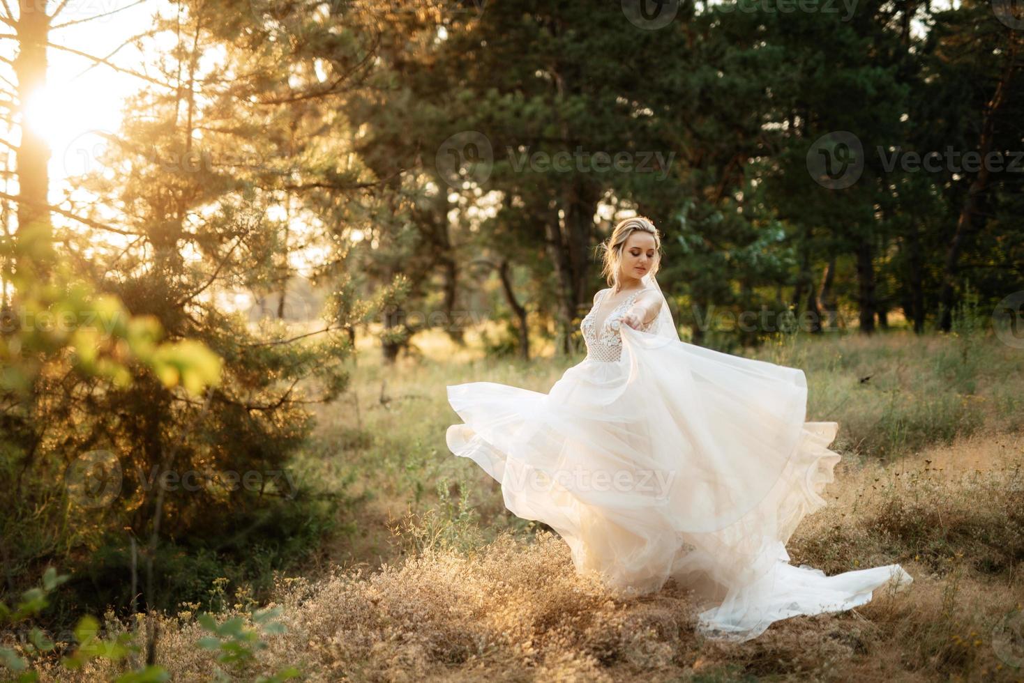 la mariée blond fille avec une bouquet dans le forêt photo