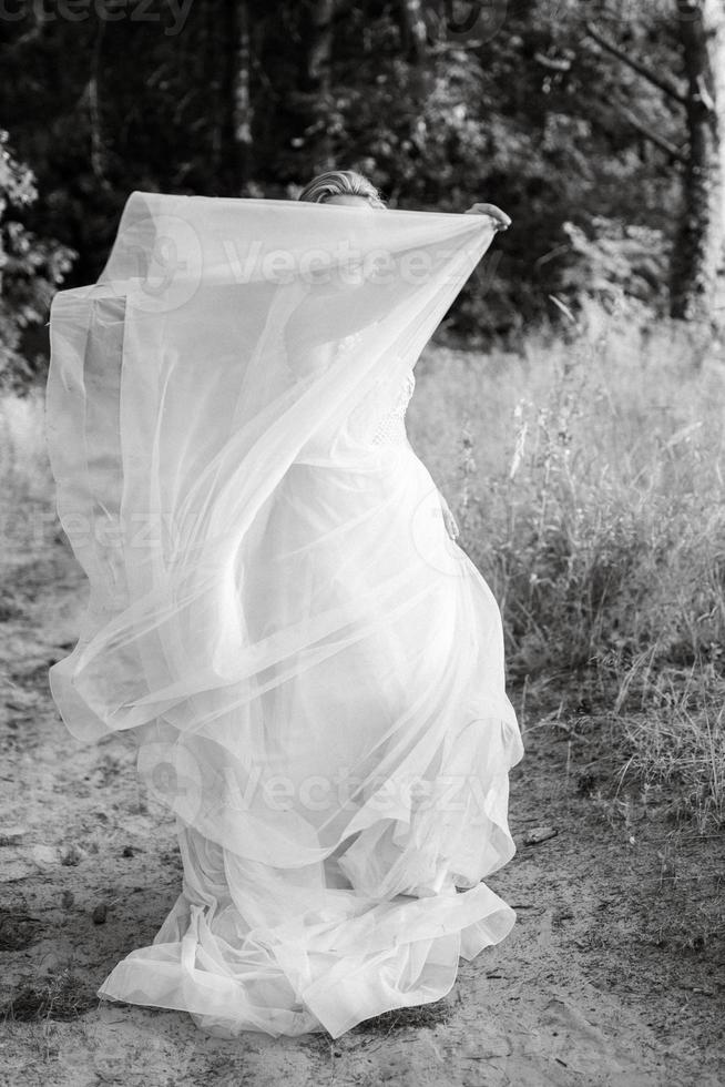 la mariée blond fille avec une bouquet dans le forêt photo