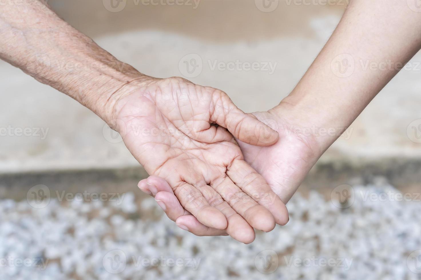 fermer de vieux et Jeune en portant mains. âge moyen celui de maman ridé mains en portant Jeune filles, une millénaire femme justificatif mature maman, montrant se soucier, et l'amour. soutien pour le personnes âgées concept. photo