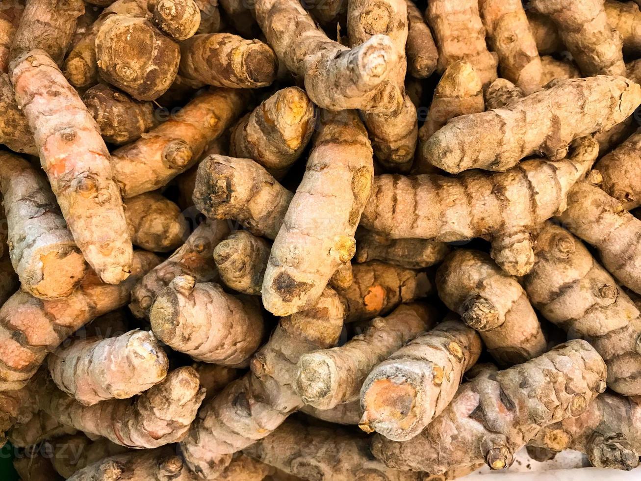 pile de Frais kunyit indonésien orthographe ou Safran des Indes curcuma longa de le gingembre famille sur vente dans marché photo