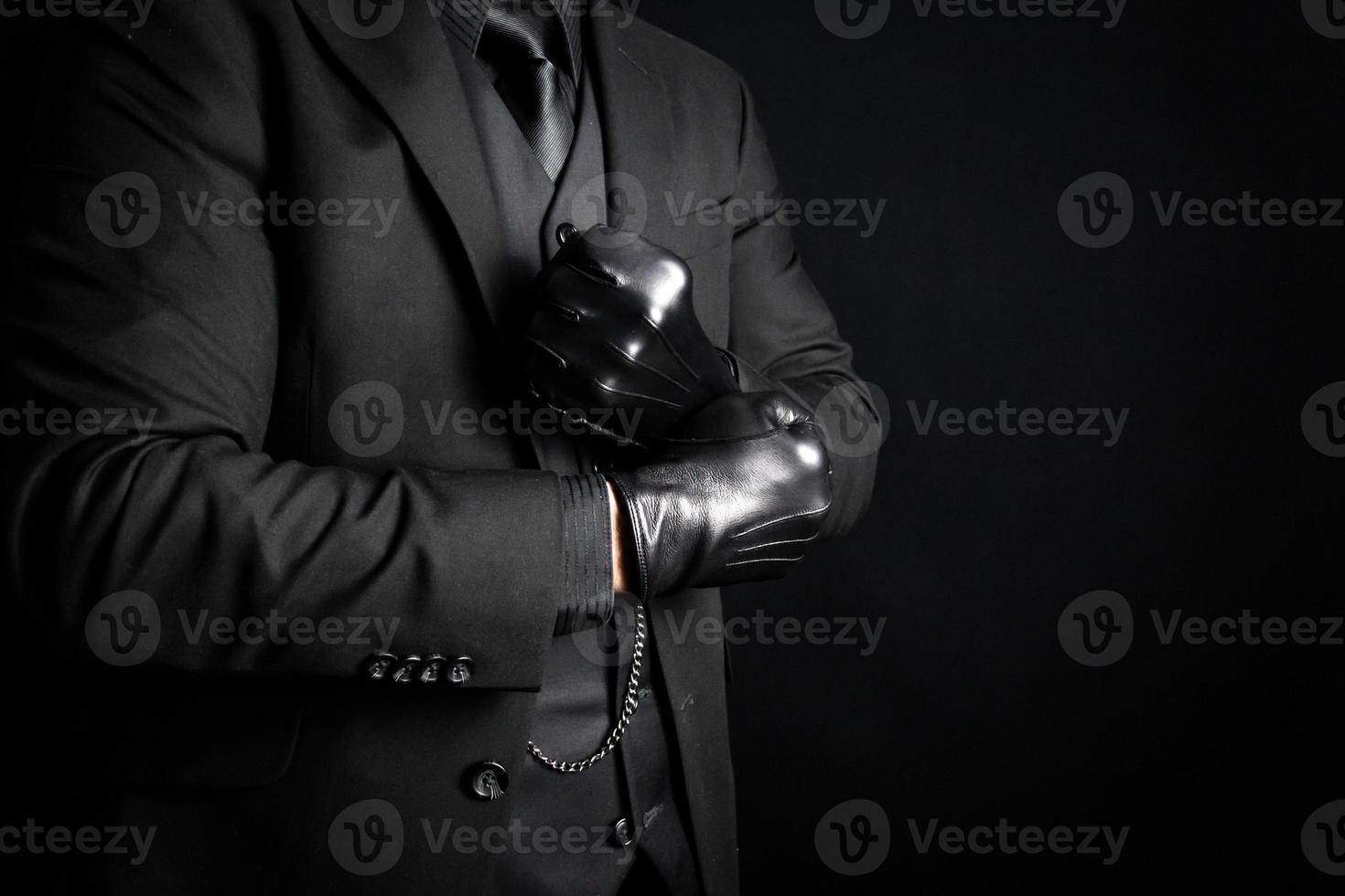 mafia bandit dans foncé costume tirant sur noir cuir gants. menace de danger et physique violence. photo