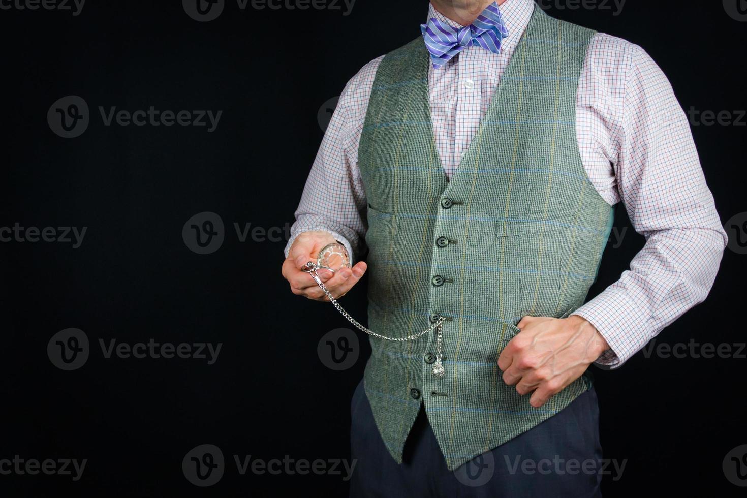 portrait de homme dans ancien tweed gilet à la recherche à poche regarder sur noir Contexte. ancien style. rétro mode. photo