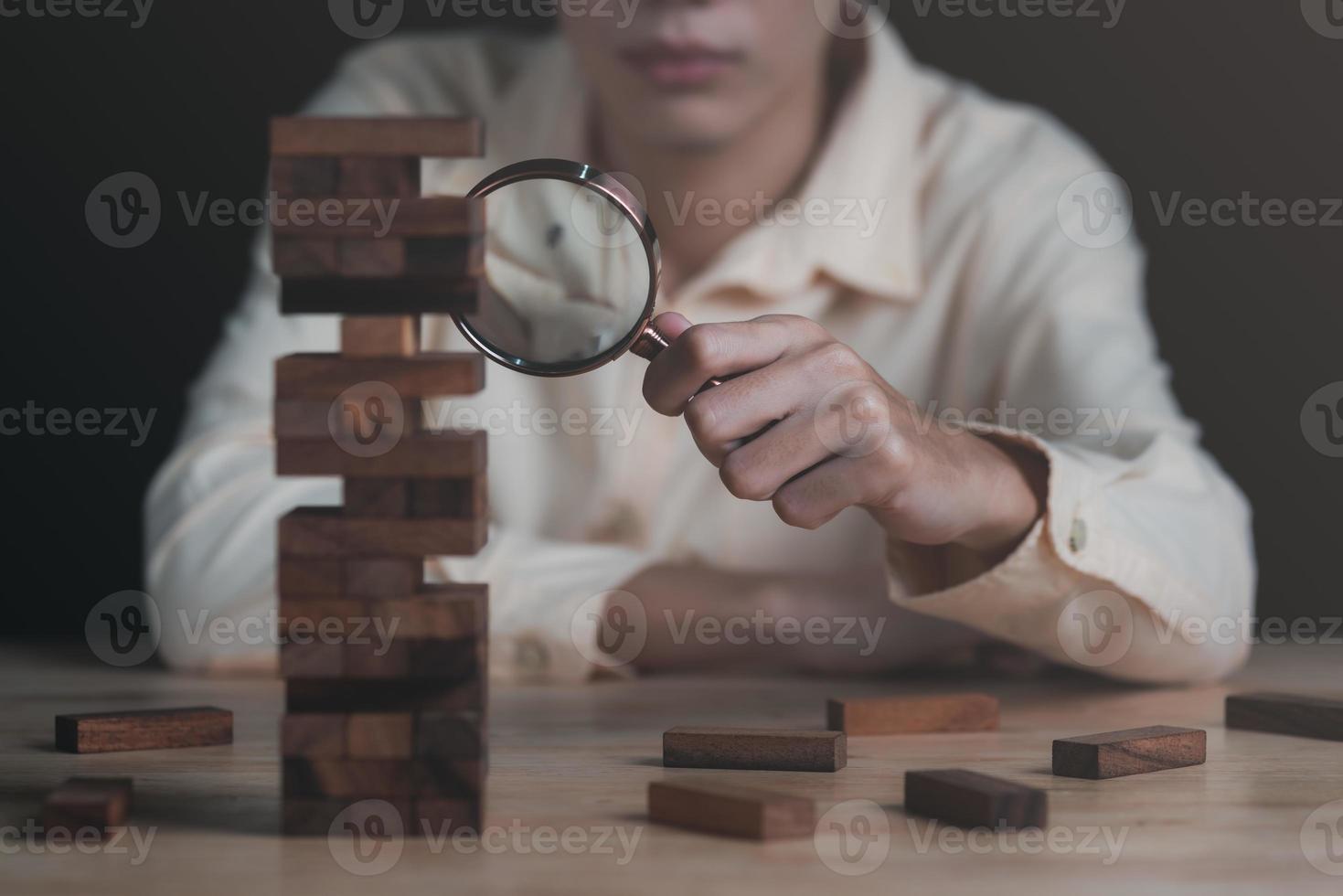 gestion des risques financiers et planification stratégique grâce à l'analyse des données pour l'amélioration continue décisions visionnaires pour le succès du leadership, un homme tenant une loupe et un bloc de bois sur la table photo