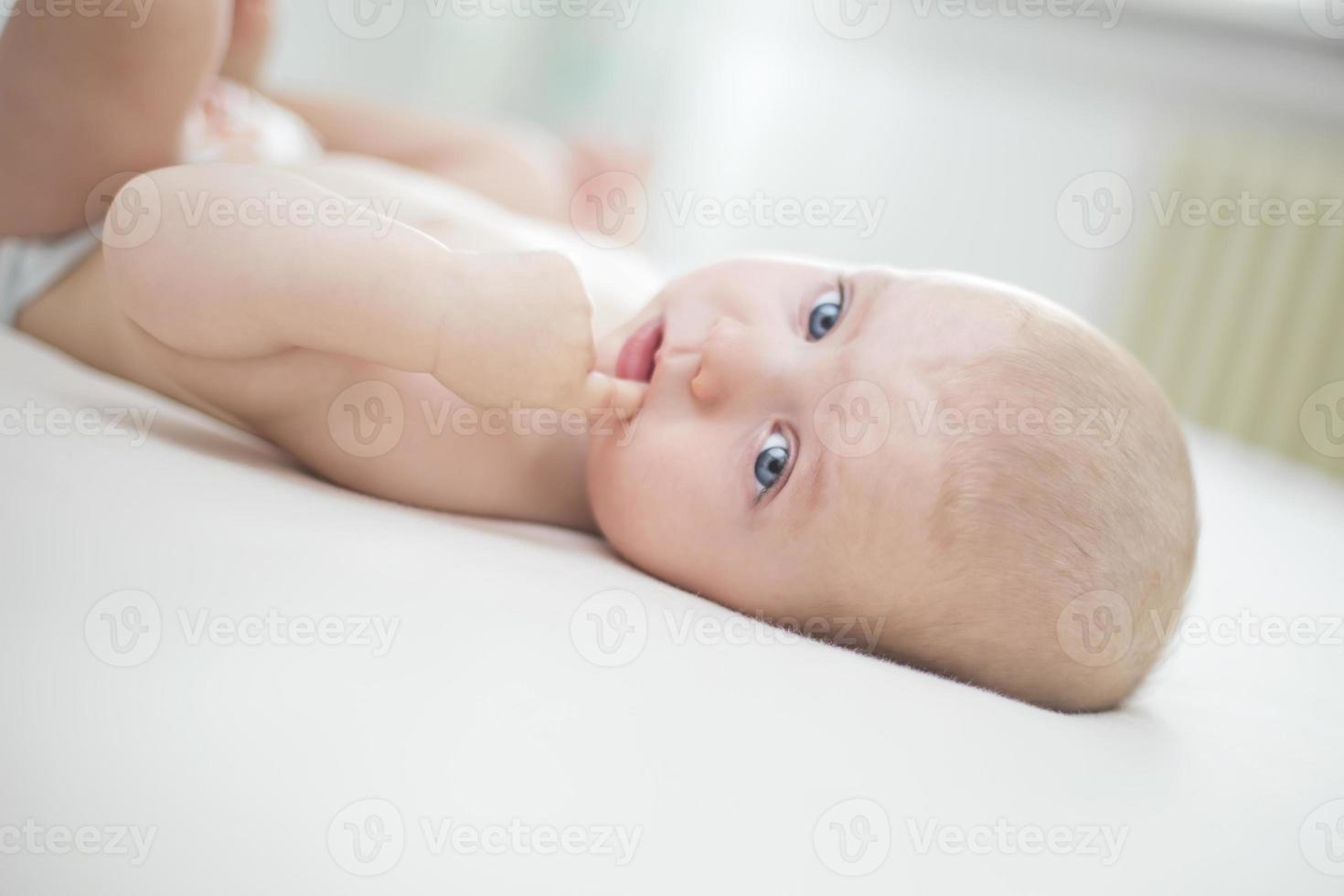 petite fille couchée avec la main dans la bouche photo