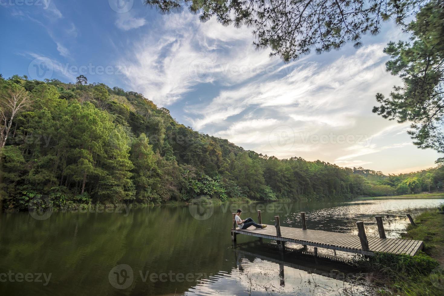 homme avec tablette se détend dans le lac de pang ung photo