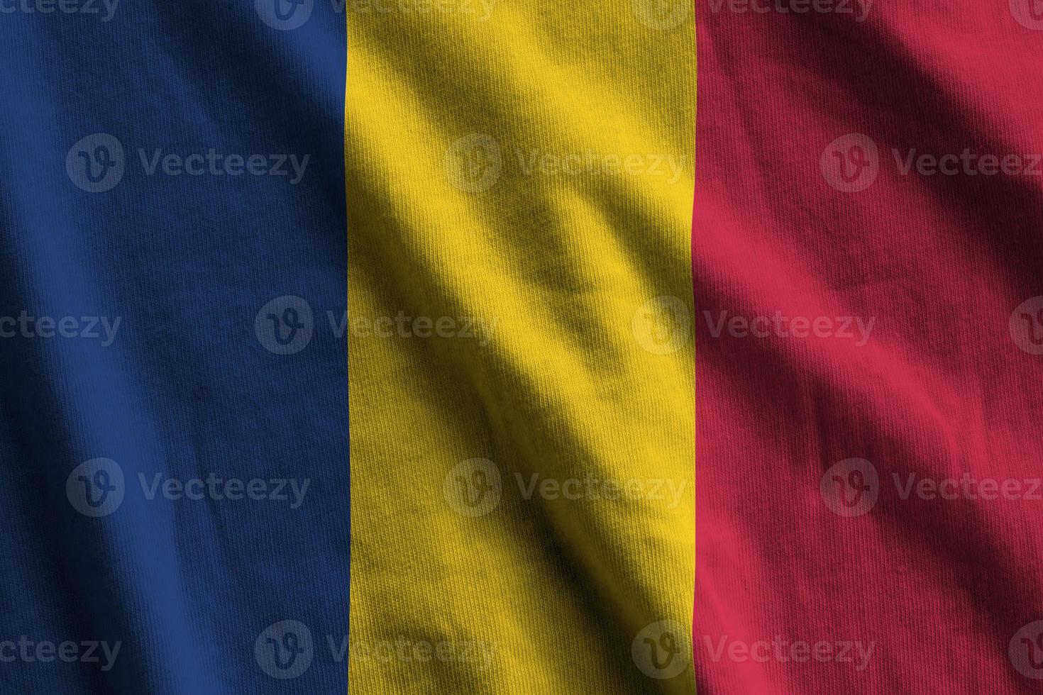 drapeau tchad avec de grands plis agitant de près sous la lumière du studio à l'intérieur. les symboles et couleurs officiels de la bannière photo