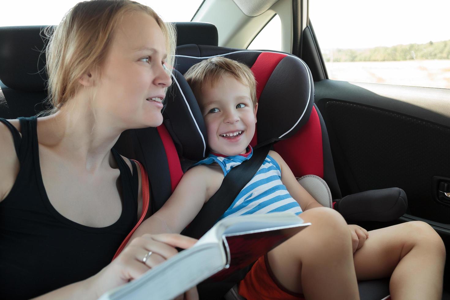 mère lisant un livre à son fils dans la voiture photo