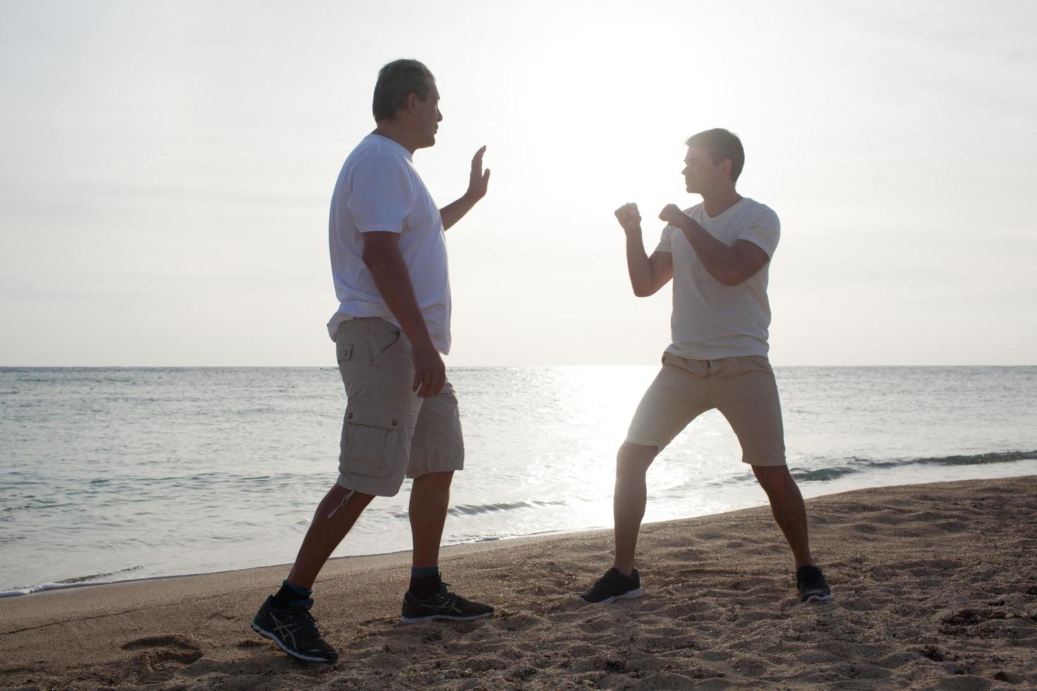 deux hommes s'entraînant sur une plage photo