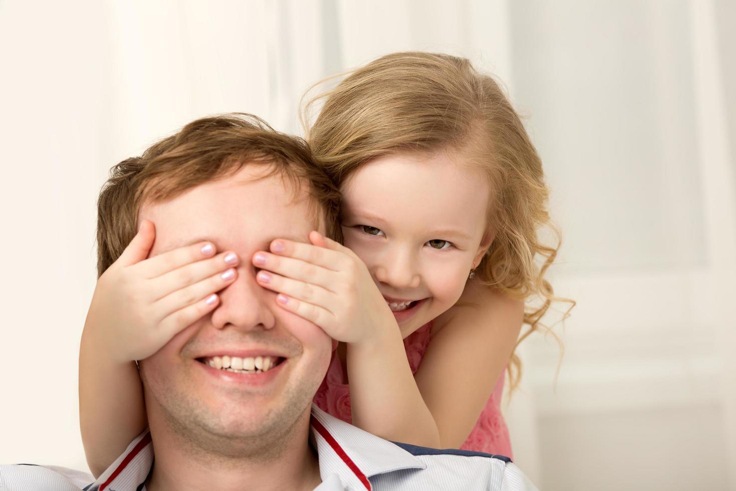 fille jouant peekaboo avec père photo