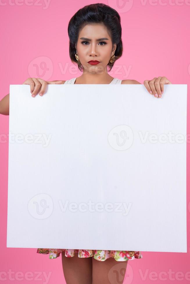 Portrait d'une femme à la mode affichant une bannière blanche photo