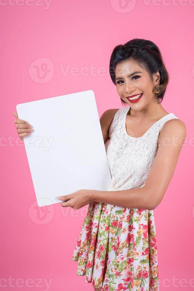 Portrait d'une femme à la mode affichant une bannière blanche photo