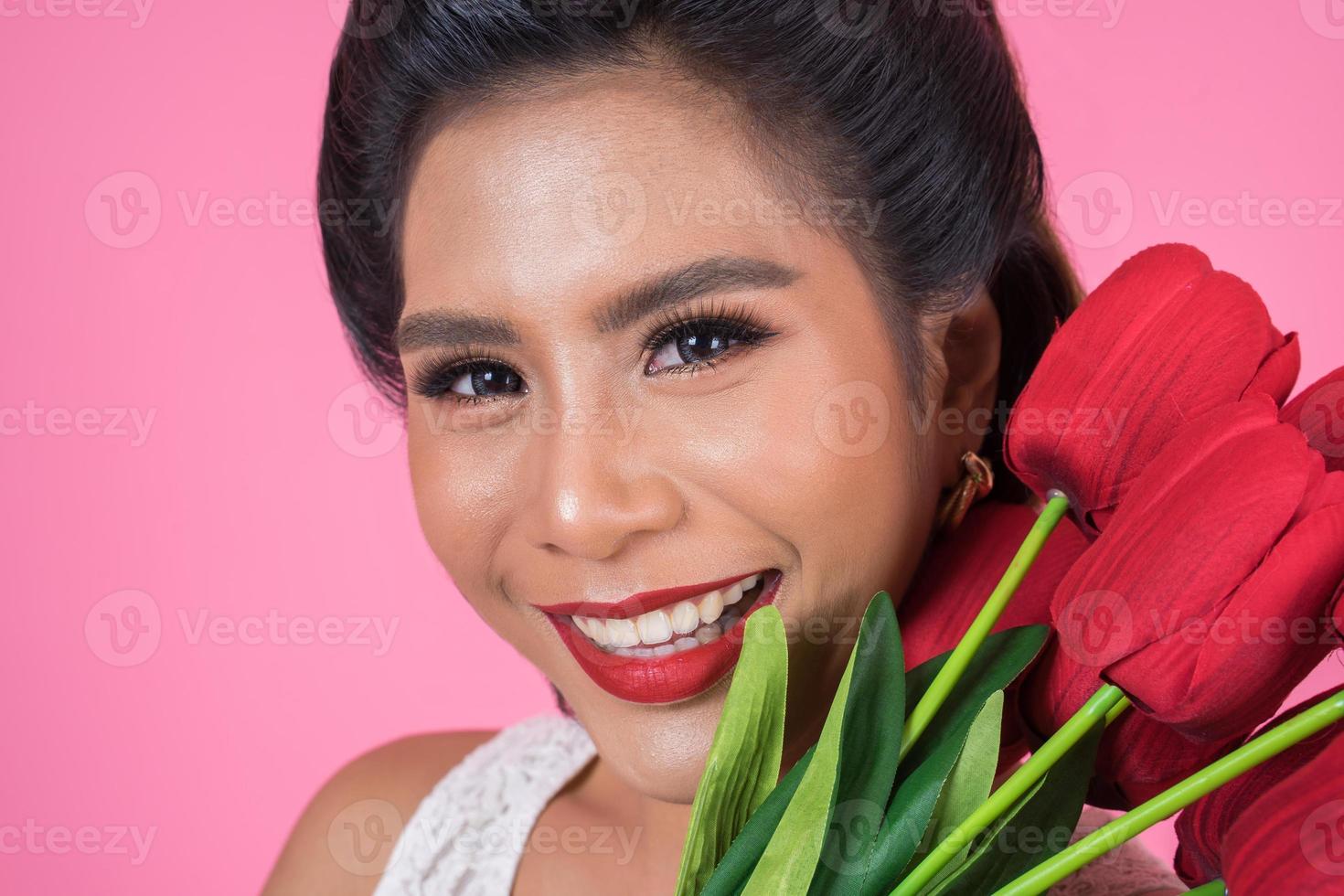 Portrait d'une belle femme avec bouquet de fleurs de tulipes rouges photo