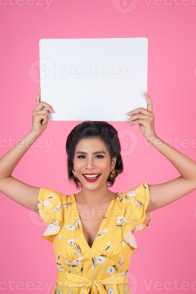 Portrait d'une femme à la mode affichant une bannière blanche photo